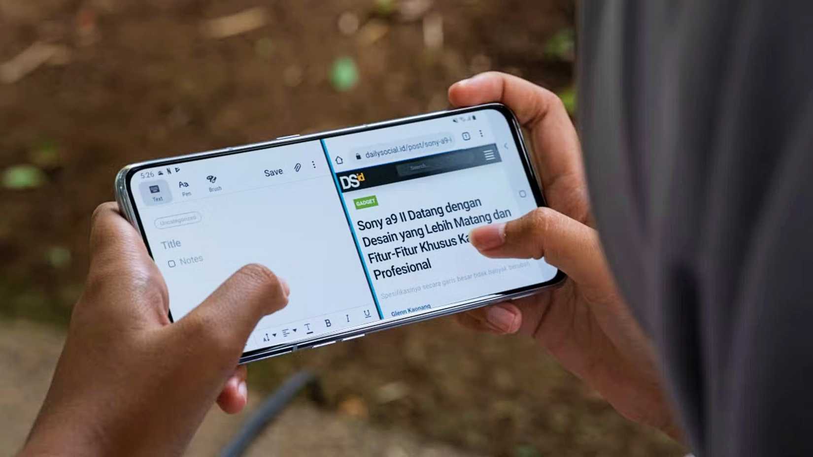 person s hands holding an android phone and using it in split screen mode